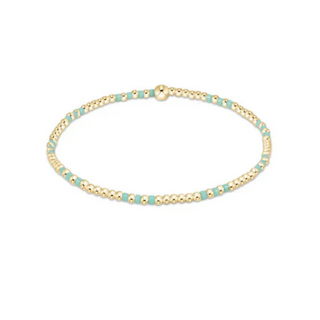 Gold and mint beaded bracelet on a white background