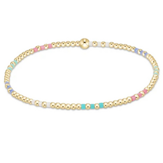 Gold beaded bracelet with colorful beads on a white background
