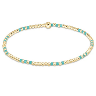 Gold and turquoise beaded bracelet on a white background
