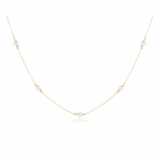 Delicate gold necklace with small pearls on a white background