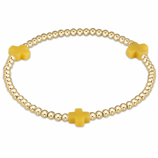 Gold beaded bracelet with yellow cross charms on a white background enewton