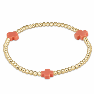 Gold beaded bracelet by enewton with coral-colored flower-shaped charms on a white background