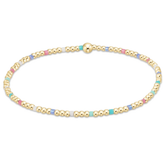 Gold beaded bracelet with multicolored beads on a white background