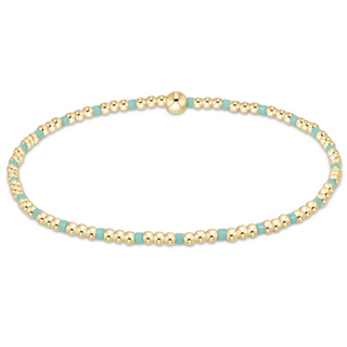 Gold and turquoise beaded bracelet on a white background