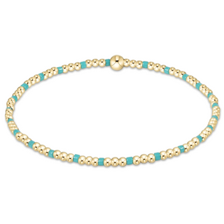 Gold and turquoise beaded bracelet on a white background