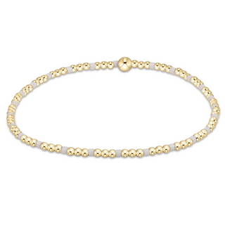 Gold and white beaded necklace on a white background