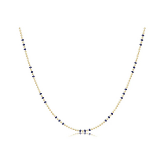 Necklace with blue beads on a gold chain against a white background by e newton