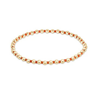 Bracelet with gold and red beads on a white background by enewton
