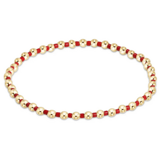 Bracelet with gold and red beads on a white background by e newton