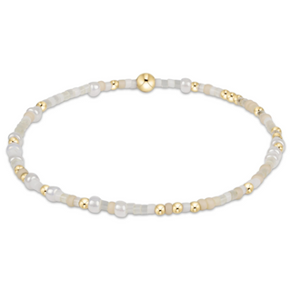 Bracelet with white and gold beads on a white background