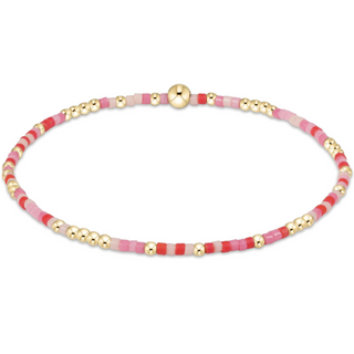 Bracelet with pink and gold beads on a white background