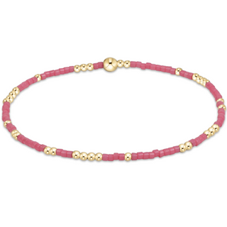 Bracelet with pink beads and gold accents on a white background