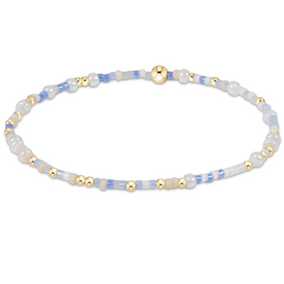 Beaded bracelet with gold and blue beads on a white background